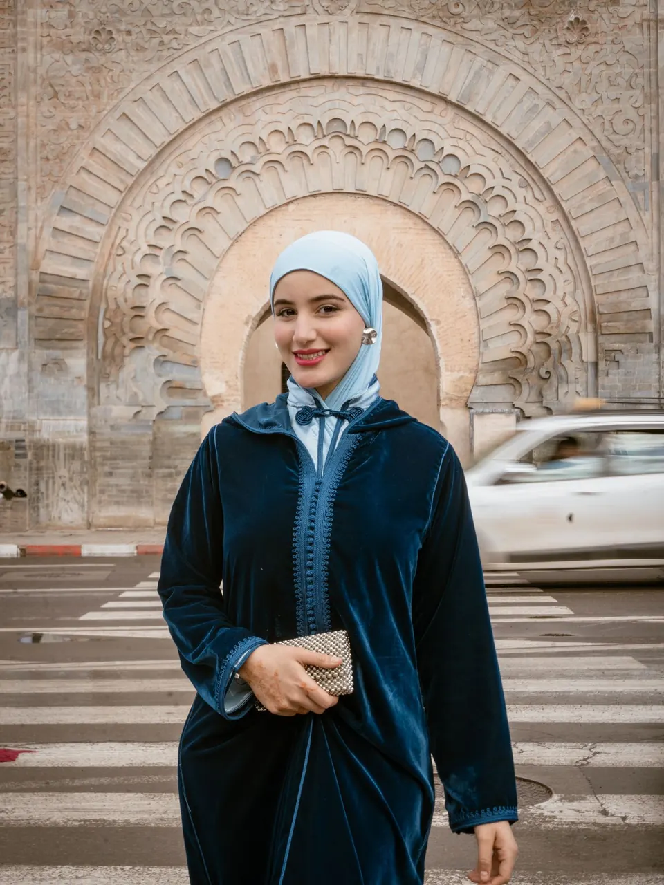 Une femme en djellaba de velours bleu nuit devant Bab Agnaou, à Marrakech