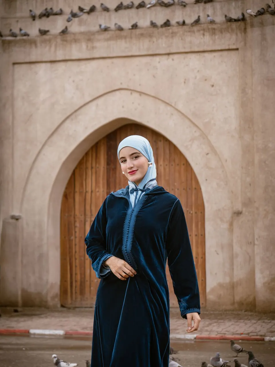 La djellaba de velours devant une porte en bois sculpté