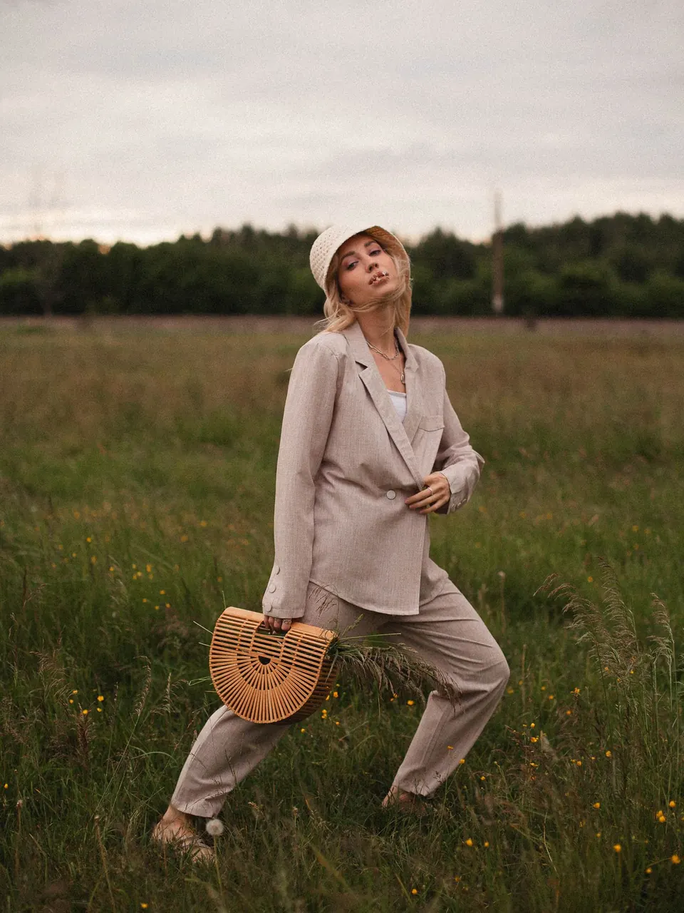 Une femme en ensemble de lin sable, blazer et pantalon, dans un champ