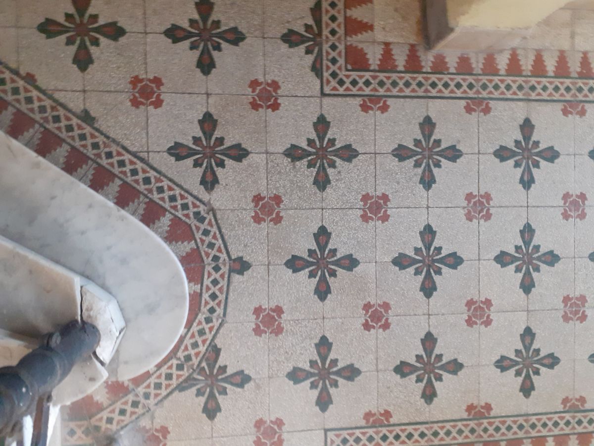 Sol en carreaux de ciment à motifs de croix et frise rouge