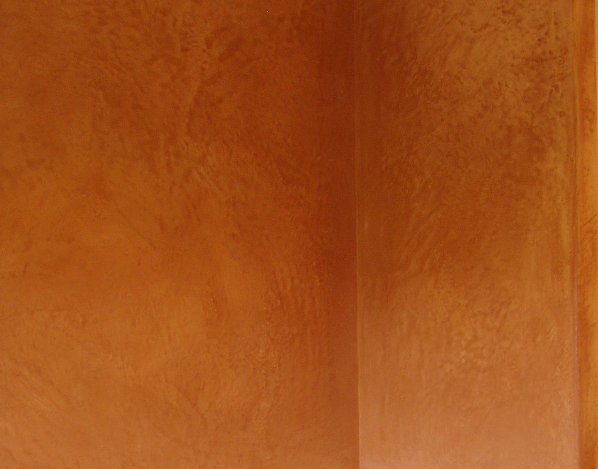 Mur en tadelakt ocre orangé, surface lustrée